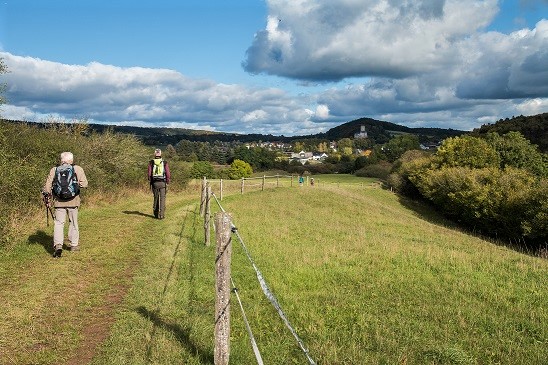 Wanderer unterwegs in der weiten Landschaft der Eifel mit dem Eifelverein